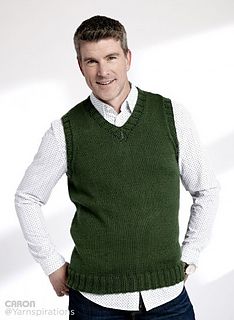 a man wearing a green sweater vest and white shirt