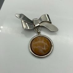 "Vintage Bow Brooch with Dangling Lucite Cabochon Circle, Graceful Lapel Pin Measurement * 2\" unmarked Condition * Very Nice Condition, No damage. Gently used. Please see pics. Size: Unisex OS Condition: Pre-Owned Good Thank you for your interest in our items! We do our best to cultivate a unique and special VINTAGE shop. Please keep in mind that when you offer Antique or Vintage items a home, you are purchasing a pre-loved item which likely has an amazing history. These items will not normally Bow Brooch, Mid Century Vintage, Vintage Shop, Sell Items, Lapel Pin, Large Prints, Lapel Pins, Vintage Shops, Brooches