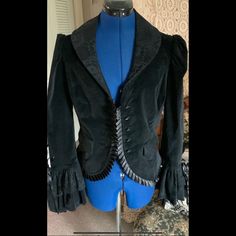 In Super Excellent New Condition, Collectible Discontinued Gorgeous Elegant Goth Cotton Velvet Jacket Has Corset Back, Dripping With Lace And Old Victorian Style Pleated Satin Trim, Buttons Look Like Antique Jet. A Rare Item. Arm Pit To Arm Pit 19” Waist 34” Or Less Back Length To Fabric Hem 22” Center Back To Bell Cuff 34” Discontinued Rare Item. Steampunk Long Sleeve Formal Outerwear, Black Blazer For Costume Events In Winter, Black Steampunk Costume Outerwear, Gothic Formal Outerwear For Fall, Formal Gothic Outerwear For Fall, Gothic Black Outerwear For Costume Party, Elegant Halloween Costume Outerwear, Gothic Long Sleeve Blazer For Winter, Gothic Black Blazer For Fall