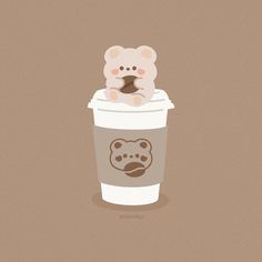 a coffee cup with a teddy bear sitting on top of it's cap in front of a brown background