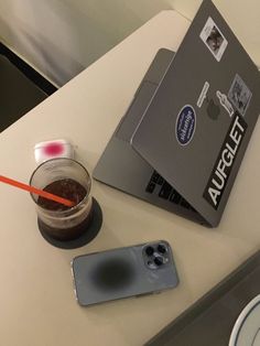 an open laptop computer sitting on top of a table next to a cup of coffee