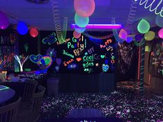 a room filled with neon lights and balloons