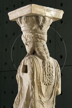 an ancient statue is shown against a black background