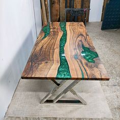 a table made out of wood and metal with green glass inlays on top