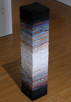 a stack of magazines sitting on top of a wooden floor next to a white wall