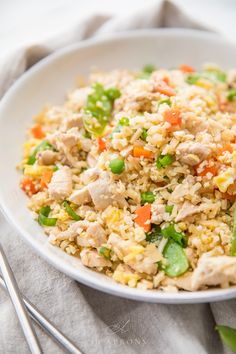 a white bowl filled with rice and vegetables