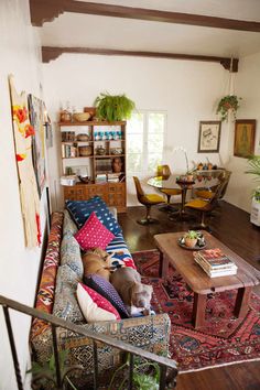 a living room filled with furniture next to a stair case in front of a window