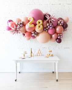 a balloon wall with the number twenty two in gold and pink balloons on top of it