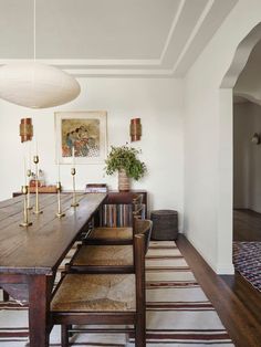 a dining room table with chairs and a rug on the floor in front of it