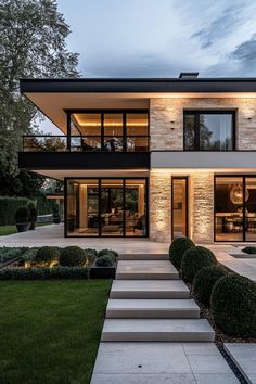 a modern house with large windows and steps leading up to it