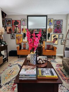 a living room filled with furniture and lots of pictures on the wall above it's coffee table