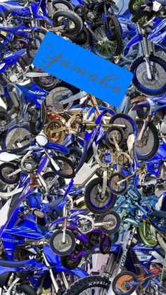 a pile of blue dirt bikes sitting next to each other