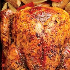 a roasted turkey in a roasting pan with onions and peppers on the side, ready to be cooked