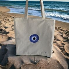 "Embroidered tote bag - Evil Eye Bag - Beach Bag - Greek gift Classic tote bag made with strong cotton fabric. For every day use. Handmade and fully lined. Material : ❤ Dimensions Medium 16\"x16\" or Small 13\"x13\" - Medium 40 x 40 cm or Small 33 x 33 cm ❤  Inside and outside fabric are made of 80% cotton and 20% polyester. It avoids that the fabric gets wrinkled and it is easy ironing ❤  Embroidered evil eye design with viscose thread - Available in 4 designs ❤  Web handles are made in the sam Vacation Cotton Bag With Embroidery, Embroidered Cotton Vacation Bag, Embroidered Cotton Bag For Vacation, White Cotton Beach Bag For Shopping, Rectangular Canvas Beach Bag Gift, White Cotton Tote Beach Bag, White Cotton Shoulder Beach Bag, White Canvas Beach Bag As Gift, White Canvas Beach Bag Gift