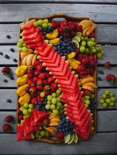 a wooden tray filled with lots of different types of fruit