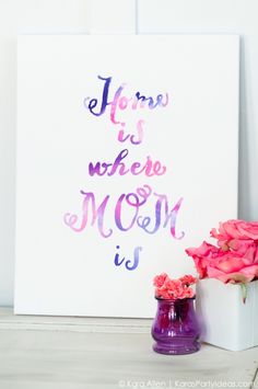 there is a purple vase with pink flowers in it next to a sign that says, home is where moon is