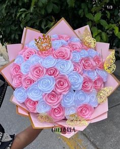 a person holding a large bouquet of pink and blue flowers