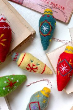 several ornaments are displayed on a table with some papers and other items in the background