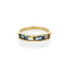 a yellow gold band with multicolored stones on the inside and outside, set against a white background