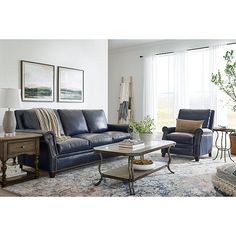 a living room with two couches and a coffee table in front of a window