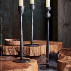 three candles sitting on top of wooden logs