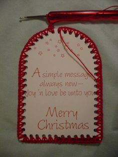 a red and white christmas ornament hanging from a string with a message on it