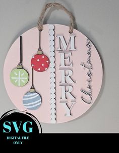 a pink christmas ornament hanging from a string on a wall with the words merry written below it