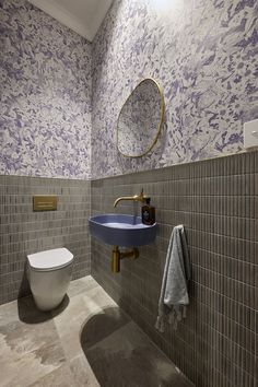 a blue sink and toilet in a small room with tile flooring, walls and ceiling