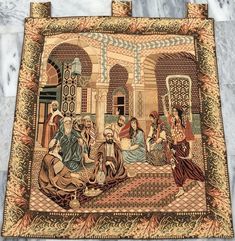 an old tapestry with people sitting around it on the floor in front of a marble wall