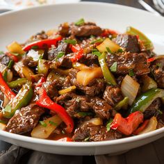 a white bowl filled with beef and peppers