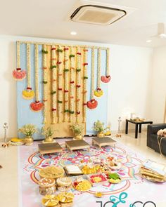 a decorated stage with food on the floor and decorations hanging from the wall behind it