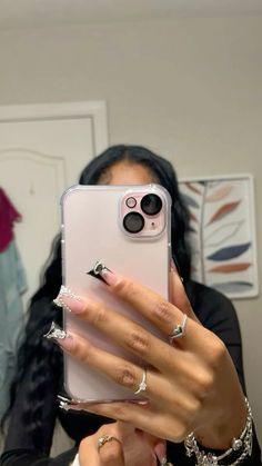 a woman taking a selfie with her cell phone in front of her earring