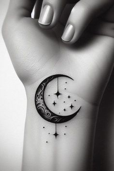 a woman's hand with a small tattoo on the wrist and a crescent moon