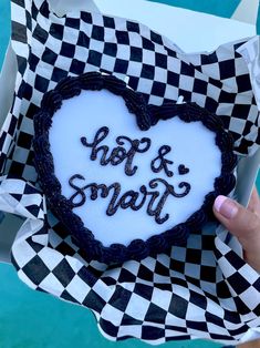 a heart shaped cookie with the words hot & smart on it in black and white checkered paper