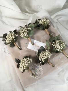 a bunch of flowers sitting on top of a white cloth covered tablecloth next to a piece of paper