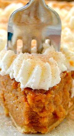 a piece of pie with whipped cream on top and a fork sticking out of it