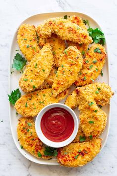 chicken nuggets with ketchup and parsley on a white platter