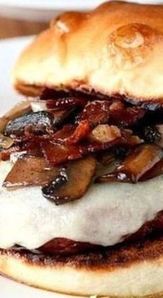 a close up of a sandwich on a plate with meat and mushrooms in the middle