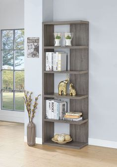 a bookshelf with several shelves and vases on the floor in front of a window