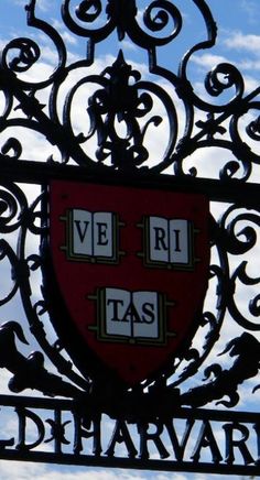 a metal gate with a red and white shield on it's side against a blue sky