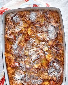 a casserole covered in powdered sugar on top of a red and white towel