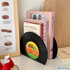 a record player sitting on top of a white table next to books and other items