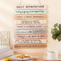 a wooden sign that says daily affirmations hanging on a wall next to a plate of cookies