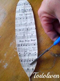 a person cutting up sheet music paper with scissors