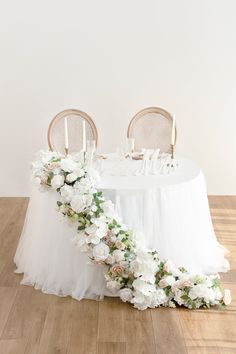 the table is decorated with white flowers and greenery