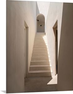 an empty hallway with white walls and stairs