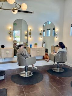 a woman is sitting in a chair at the hair salon