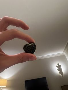 a person holding a rock in their hand with the light on above them and below it