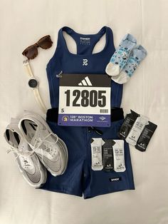 a woman's running outfit and shoes on a bed