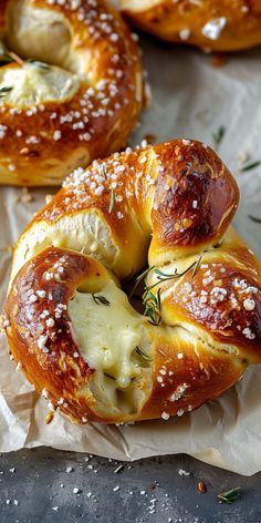 several bagels with cheese and herbs on them sitting on top of waxed paper